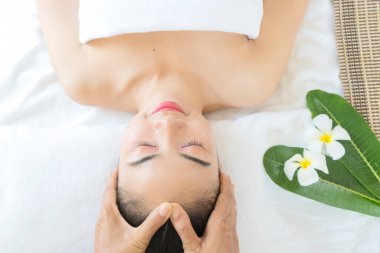 Güzellik uzmanı kadının yüzüne masaj yapıyor. Çekici kız yüz bakımı ve masaj yaptırıyor. Genç kadın yalan söylüyor ve dinleniyor..