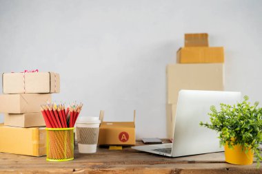 İş yerindeki dizüstü bilgisayar, küçük işletme sahibi. Müşteriye teslim etmek için karton kutu ürün. Çevrimiçi satış, e-ticaret, paketleme konsepti