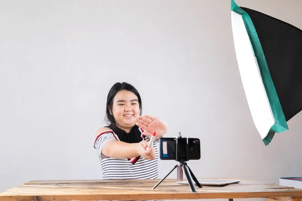 年轻亚洲女人的肖像影评送礼产品粉丝跟随频道 在家里录影组成唇膏化妆品 网上影响者女孩社交媒体营销直播概念 — 图库照片