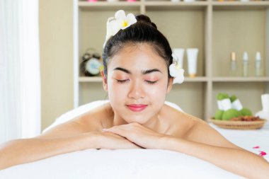 Kaplıca salonunda gözleri kapalı, masaj için bekleyen rahat bir kadın.