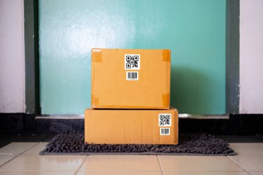 Kapının önüne bir paket kutusu yerleştirilmiş. Karantina, salgın sırasında temassız doğum. Evde kal, online alışveriş..