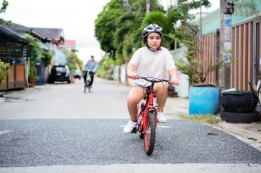 Babası küçük çocuğuna sonbahar parkında bisiklet sürmeyi öğretiyor. Mutlu aile anları. Baba oğul birlikte vakit geçiriyoruz. Gizli yaşam tarzı resmi.