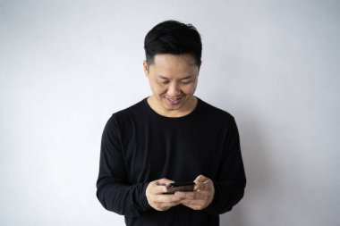 Modaya uygun genç sakallı adamın şık kıyafetler giymesine, şık saç stiline sahip olmasına, arkadaşlarıyla mesajlaşmaktan mutlu olmasına, elektronik aletler üzerinde ücretsiz internet bağlantısı kullanmasına memnun.