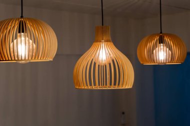 Modern ahşap kolye tavan lambalarını parlak ampullerle kapatın. Ev ya da restoran için iç dekorasyon konsepti. Sıcak ışıklandırma tasarımı şık bir atmosfer ve çağdaş yaşam tarzı yaratıyor.