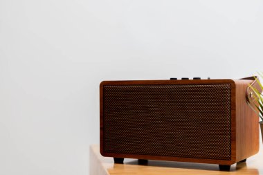 Retro wooden speaker placed on a minimalist table, showcasing warm texture and modern functionality. Ideal for themes of home decor, audio technology, lifestyle, and interior design.