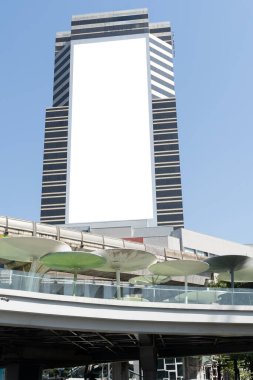 Şehrin modern gökdelen cephesinde boş bir reklam panosu modeli, açık hava reklamcılığı, markalaşma ve temiz kopya alanı olan kurumsal pazarlama için ideal. Kesme yolu.
