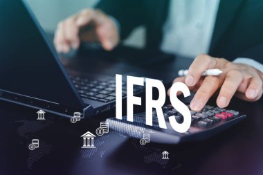 Dizüstü bilgisayarı ve hesap makinesi ile IFRS metin kaplamalı iş profesyonel hesaplama rakamları. Uluslararası muhasebe standartları, uyum, denetim, vergilendirme ve küresel finans raporlama kavramı.