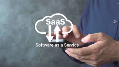 SaaS bulut sembollü akıllı telefonu kullanan eller, yazılımı hizmet olarak temsil eden, çevrimiçi uygulamalar, abonelik platformu, veri yükleme ve indirme ve iş için bulut teknolojisi.