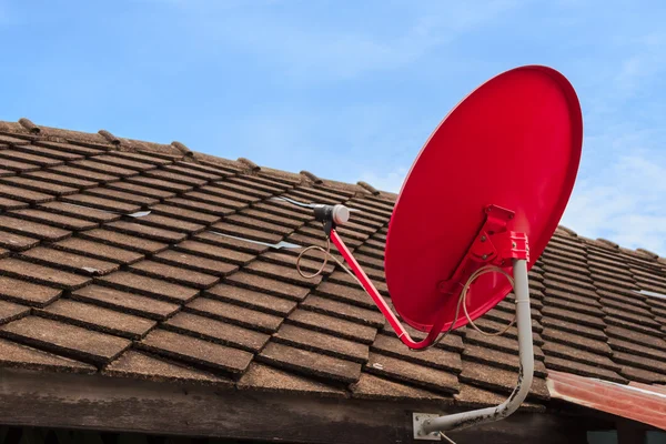 Prato receptor de TV por satélite vermelho no telhado telhas velhas — Fotografia de Stock