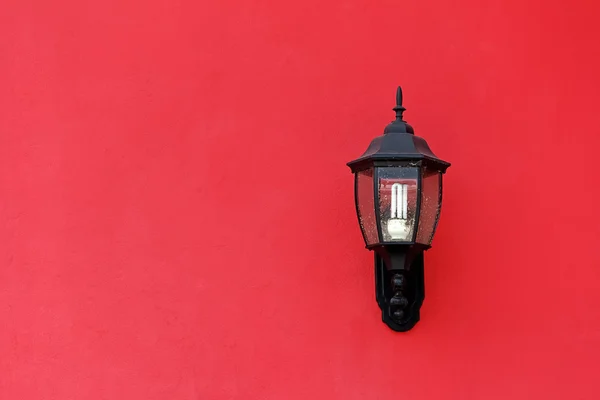 Vecchia lanterna sulla parete di cemento rosso — Foto Stock