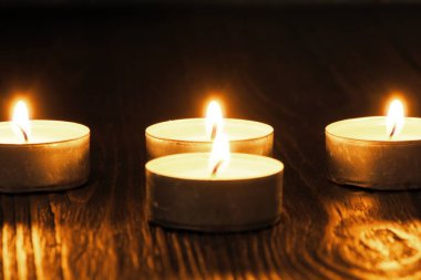 Mum yakıyorum. Yüzeyin derinliği. Geceleri bir sürü Noel mumu yanıyor. Soyut mum arkaplanı. Karanlık arka planda parlayan bir sürü mum alevi var. Yakın plan. Boş alan.