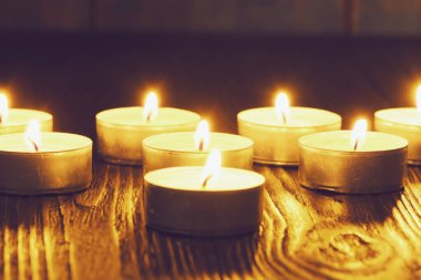 Mum yakıyorum. Yüzeyin derinliği. Geceleri bir sürü Noel mumu yanıyor. Soyut mum arkaplanı. Karanlık arka planda parlayan bir sürü mum alevi var. Yakın plan. Boş alan.