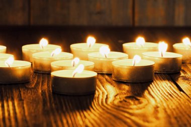Mum yakıyorum. Yüzeyin derinliği. Geceleri bir sürü Noel mumu yanıyor. Soyut mum arkaplanı. Karanlık arka planda parlayan bir sürü mum alevi var. Yakın plan. Boş alan.