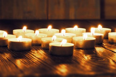 Mum yakıyorum. Yüzeyin derinliği. Geceleri bir sürü Noel mumu yanıyor. Soyut mum arkaplanı. Karanlık arka planda parlayan bir sürü mum alevi var. Yakın plan. Boş alan.