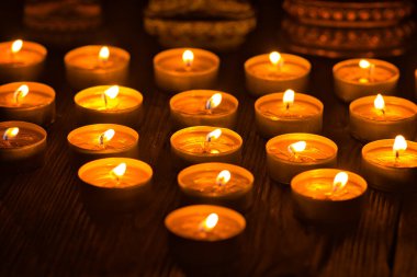 Mum yakıyorum. Yüzeyin derinliği. Geceleri bir sürü Noel mumu yanıyor. Soyut mum arkaplanı. Karanlık arka planda parlayan bir sürü mum alevi var. Yakın plan. Boş alan.