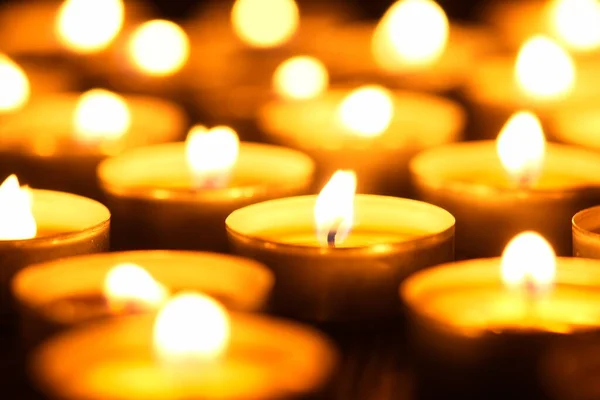 Mum yakıyorum. Yüzeyin derinliği. Geceleri bir sürü Noel mumu yanıyor. Soyut mum arkaplanı. Karanlık arka planda parlayan bir sürü mum alevi var. Yakın plan. Boş alan.