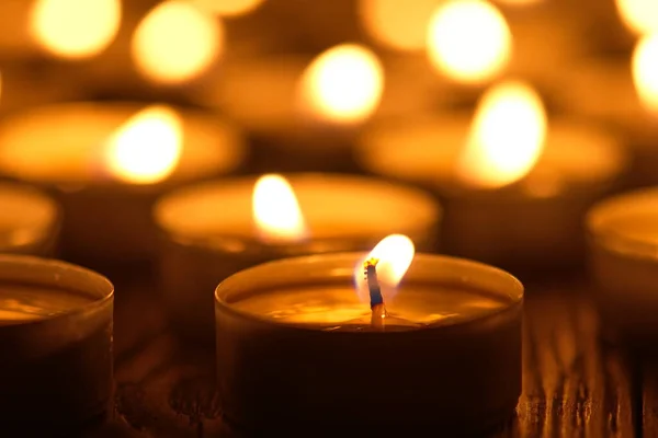 Mum yakıyorum. Yüzeyin derinliği. Geceleri bir sürü Noel mumu yanıyor. Soyut mum arkaplanı. Karanlık arka planda parlayan bir sürü mum alevi var. Yakın plan. Boş alan.