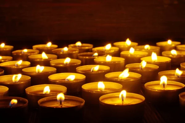 Mum yakıyorum. Yüzeyin derinliği. Geceleri bir sürü Noel mumu yanıyor. Soyut mum arkaplanı. Karanlık arka planda parlayan bir sürü mum alevi var. Yakın plan. Boş alan.