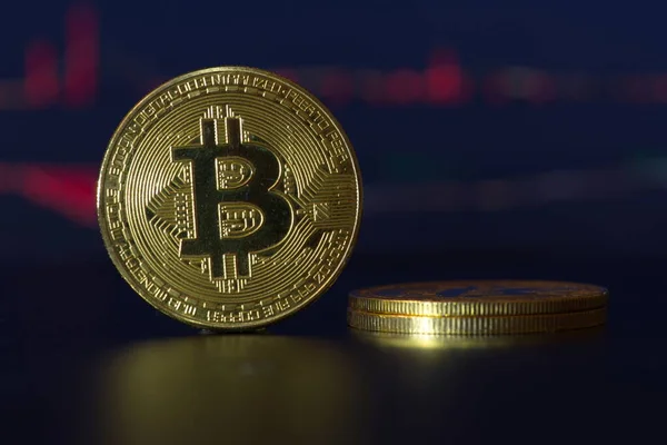 Bitcoinler ve sanal para konsepti. Şifreleme parasının büyüyen ve azalan değerinin grafiği olan madeni paraların üzerindeki altın bitsikkeler. Madencilik ya da engelleme teknolojisi. 