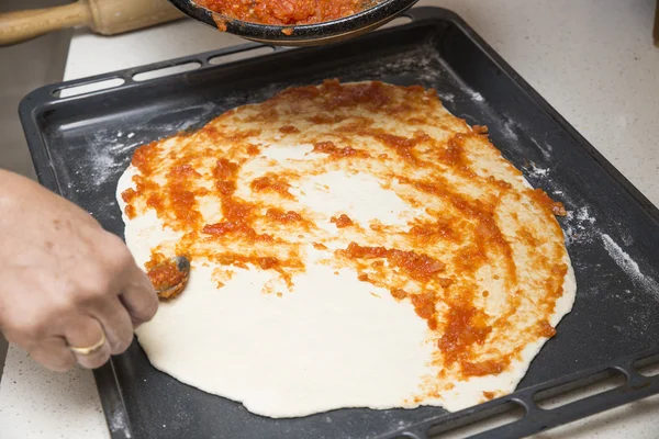 Förbereder pizzadeg med tomat — Stockfoto