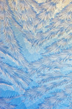 Soğuk bir kış sabahı pencere camında buz şekilleri oluşur.