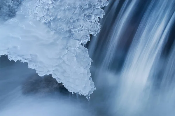 Landscape of winter waterfall framed by ice and captured with motion blur, Orangeville Creek, Michigan, USA