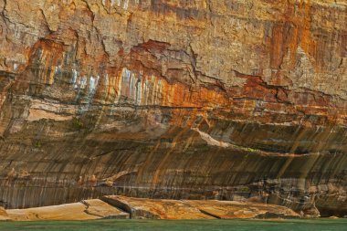 Superior Gölü 'nün aşınmış kumtaşı kıyı şeridi boyunca uzanan mineral lekeli uçurumun soyut manzarası, Resimli Kayalar Ulusal Lakeshore, Michigans Yukarı Yarımadası, ABD