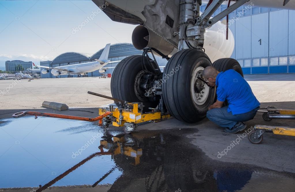 Engineer repairing aircraft landing gear Stock Photo by ©brokenrecords