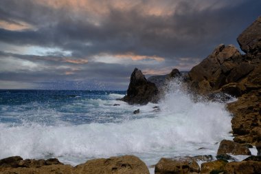 Kayalarla ve okyanus dalgalarıyla kaplı bir manzara. Lagos, Portekiz