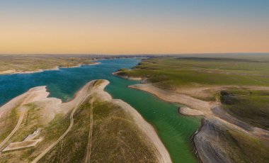 Yeşil tepelerle çevrili nehir manzarası