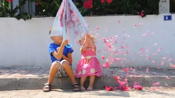 Дети с зонтиком и цветами — стоковое видео