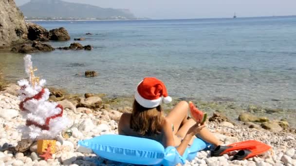 Jeune femme se détendre sur la plage avec arbre de Noël — Video