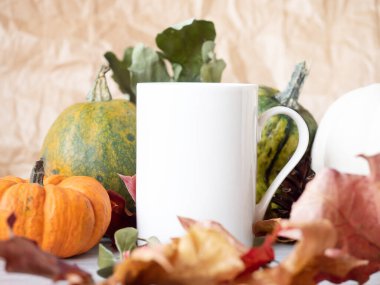 Sonbahar arka planında beyaz çay fincanının yakın çekimi 