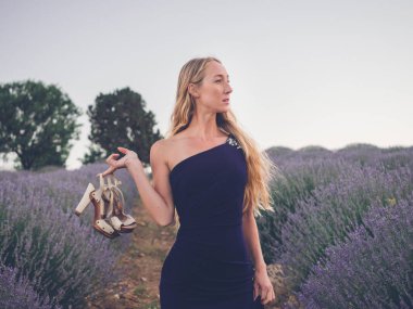 Lavanta tarlasında yürüyen sarışın beyaz kadın. 