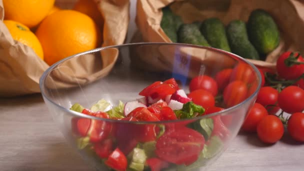 Peper toevoegen aan groentesalade van tomaten, komkommers en sla — Stockvideo