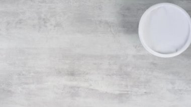 El masaya yuvarlak yiyecek konteynırları koyar.