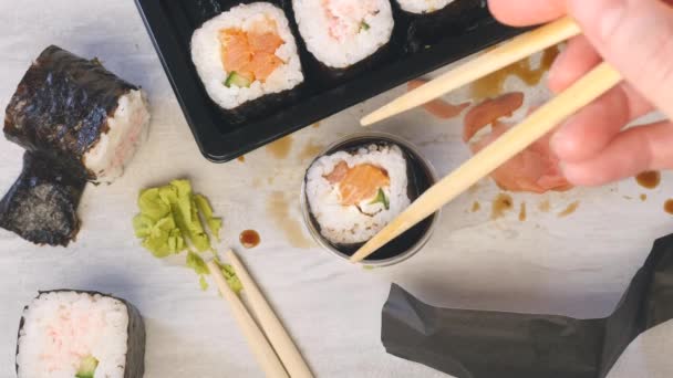 Κρατήστε σούσι με ξυλάκια και βάλτε το σε σάλτσα σόγιας. Mess στο τραπέζι — Αρχείο Βίντεο