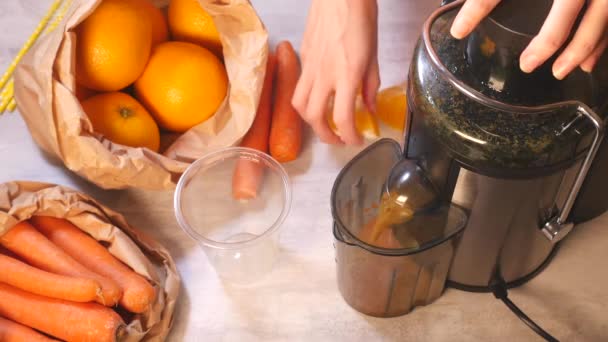 Γυναικεία χέρια που ετοιμάζουν φρέσκο καρότο και χυμό πορτοκάλι — Αρχείο Βίντεο