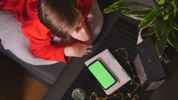 Netter Junge liegt mit Smartphone auf Sofa — Stockvideo