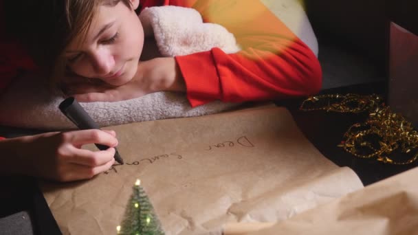 Мальчик-подросток пишет Санте длинное письмо — стоковое видео