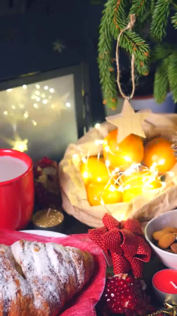 Вертикальное видео. Зимний стол с горячим шоколадом, булочками и мандаринами — стоковое видео