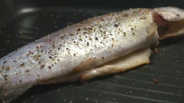 Kızartma tavasında gökkuşağı alabalığı pişiriyorum. 