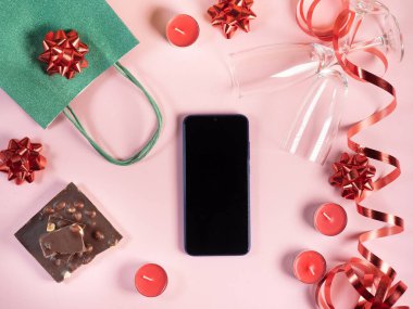 Akıllı telefon modelleme Sevgililer Günü geçmişi. Hediye, mumlar, pembe arka planda gözlük.