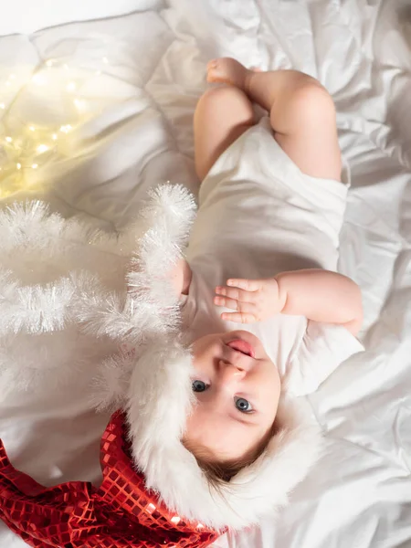 Schattig meisje in Santa hoed liggend op het bed — Stockfoto