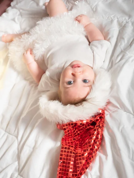 Adorável bebê menina em Santa chapéu deitado na cama — Fotografia de Stock