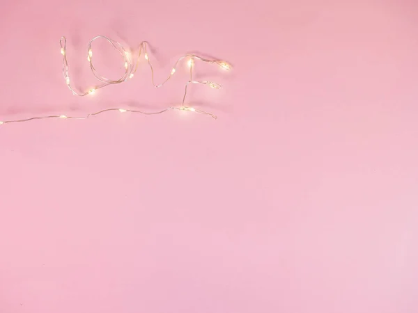 Elektrikli ışıklar pembe arkaplana aşk metni konur