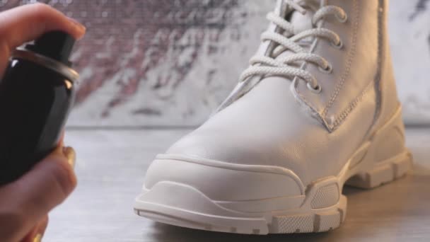 Χρησιμοποιώντας αδιάβροχο σπρέι για λευκό χρώμα χειμερινό παπούτσι — Αρχείο Βίντεο