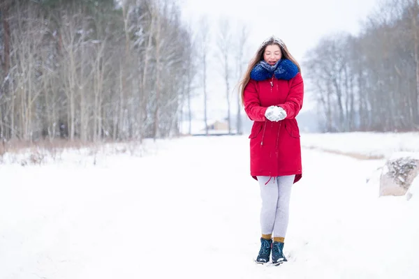 Young woman in red coat walk on winter road — Stock Photo, Image