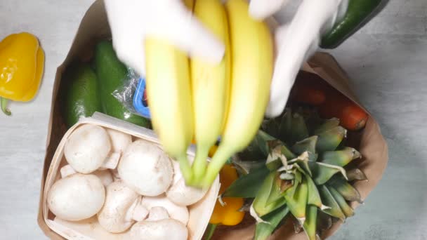 Mulher mão colocar frutas e legumes em saco de papelão — Vídeo de Stock