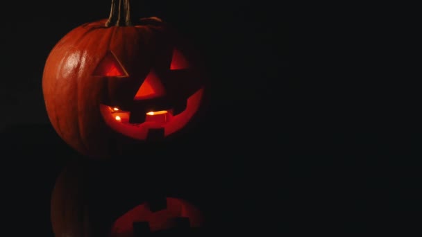 Halloween glühender Kürbis auf schwarzem Hintergrund — Stockvideo